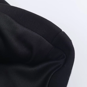 Macro view of black knit fabric texture and high-quality edge stitching on a jumpsuit