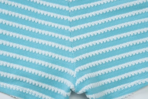 Macro detail of sky blue and white striped seersucker knit fabric texture with fine stitching