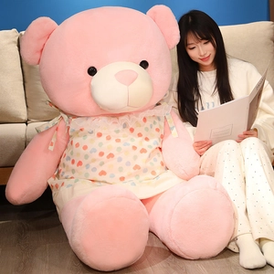 Gros ours en peluche rose avec tablier à cœurs, présenté à côté d'un mannequin