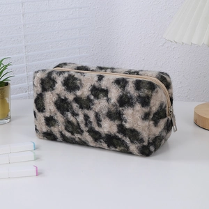 Close-up of leopard print plush makeup bag with silver zipper on a white desk