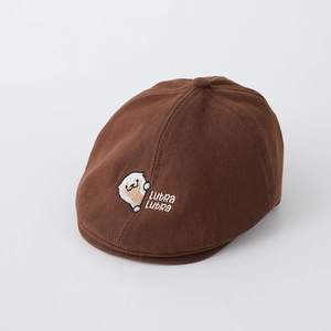 Gros plan sur la broderie de loutre et le texte Lutra Lutra sur un béret marron en coton