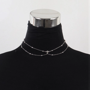 Detail of silver double-layer body chain necklace with beads and sparkling diamond pendant