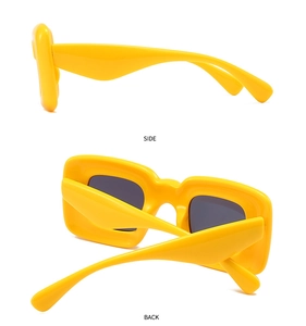 Detail view showing the side and back silhouette of yellow futuristic thick frame sunglasses