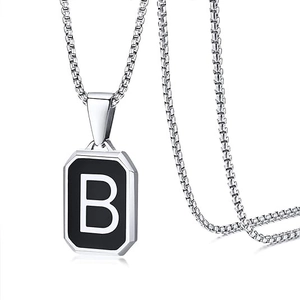Detailed macro shot of silver box chain with square black pendant featuring white letter B