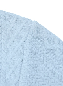 Macro view of light blue knitted shirt fabric with geometric jacquard diamond patterns