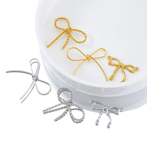 Macro view of bow butterfly charms in gold and silver finishes for jewelry making