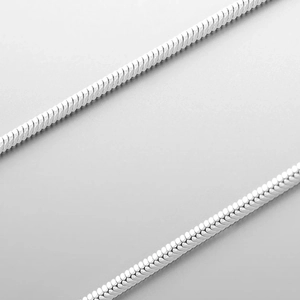 Macro detail of silver snake bone chain featuring dense seamless weaving and metallic shine