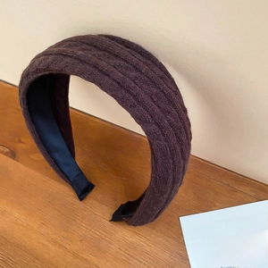 Gros plan détaillé d'un bandeau en maille marron avec texture côtelée sur bois