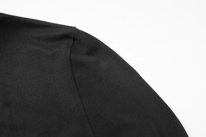 Gros plan sur la couture d'épaule et la texture en tricot fin d'un t-shirt noir ajusté