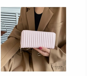 Close-up of pink long wallet with vertical quilted pleats and gold zipper detail