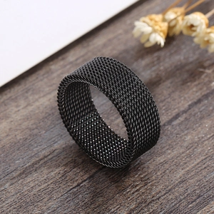 Close-up of black mesh stainless steel ring with intricate woven texture on wood