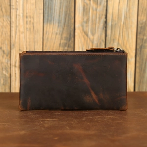 Close-up of vintage brown crazy horse leather wallet on rustic wooden surface