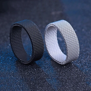 Detail view of woven mesh texture rings in black and silver finishes on dark background