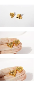 Detail of gold heart earrings with molten lava texture and sparkling zircon center