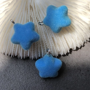 Close-up of blue flocked star pendants with silver rings for DIY jewelry making