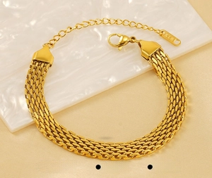Detail of gold woven mesh stainless steel bracelet with lobster clasp and K18 tag