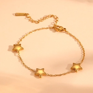 Detail of gold star bracelet featuring three 18k pendants and adjustable extension chain