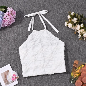 Detail of white cropped halter top featuring textured 3D floral embossed fabric finish