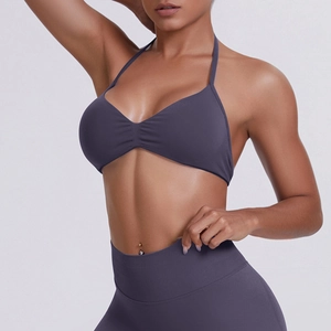 Detail of seamless halter neck sports bra and high waist leggings in dark purple fabric