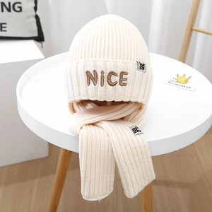 Detail of cream knit beanie and scarf set featuring NICE embroidery on high-quality yarn