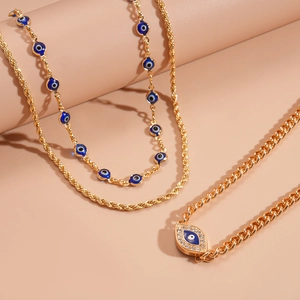 Three-piece gold layered necklace set with blue evil eye beads and crystal pendants