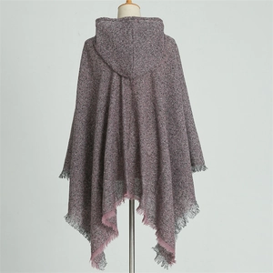Detail of hooded knit poncho cape featuring pink plaid patterns and tassel trim details