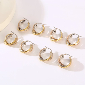 Three-tone intertwined hoop earrings in gold, silver, and rose gold with textured finish