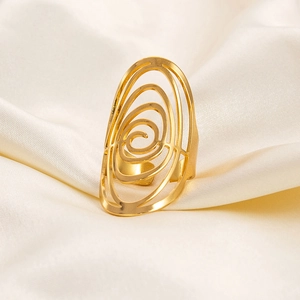 Macro detail of irregular gold oval ring with spiral hollow design on white silk fabric