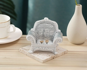 Close-up of silver velvet sofa jewelry stand with floral earrings on a stone base