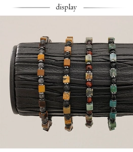 Detail showing natural tiger eye and lava stone beaded bracelets on black display roll