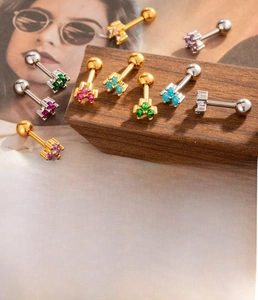Macro detail of silver and gold cartilage studs with technical size and material specifications