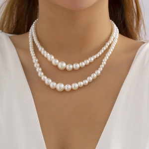 Close-up of double layer faux pearl necklace with graduated size design on a model