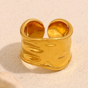 Detail view of gold wide open ring featuring unique irregular lava texture and hammered finish
