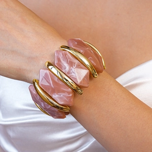 Détail de résine marbre rose et métal doré poli sur un bracelet élastique large