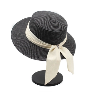 Classic black flat-top straw sun hat with wide brim and white ribbon bow accent