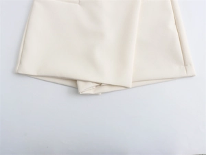 Detail des asymmetrischen Saums und der beigen Stoffstruktur dieser stylischen Skorts