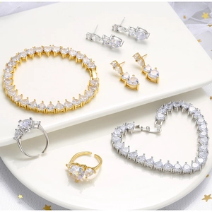 Detailed view of pink zircon heart jewelry set with 18k gold plating on marble texture