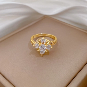Detail of gold flower ring with sparkling zircon stones on a champagne jewelry box
