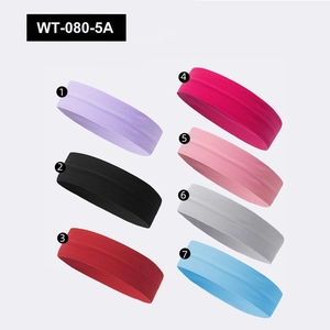 Flat lay of seven elastic sports headbands in purple, red, and blue knitted fabric