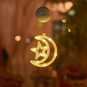 Close-up of a warm white star and moon LED suction cup light on a glass window