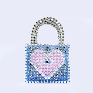 Detail of handmade beaded tote with blue heart and evil eye pattern in a macro shot