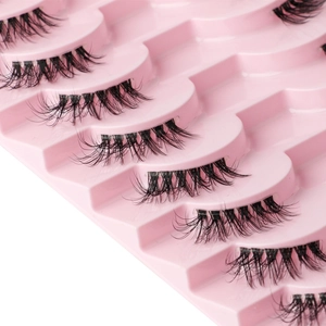 Close-up of 8 pairs of dense natural curly black false eyelashes in a pink tray