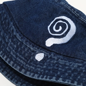 Macro detail of high-quality white spiral embroidery on navy blue denim bucket hat fabric