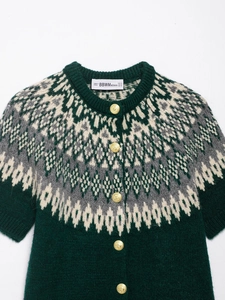 Detailed close-up of dark green Fair Isle knit cardigan with gold buttons and patterns