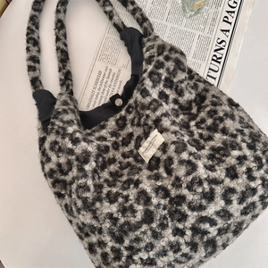 Detail of leopard print faux shearling tote bag with snap button and woven label