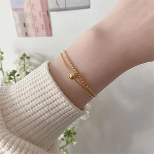 Double-layered gold beaded snake bone bracelet shown on a wrist for women