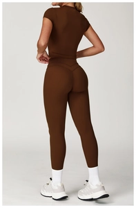 Detail of cross-back yoga top and high-waisted leggings in matte dark brown fabric
