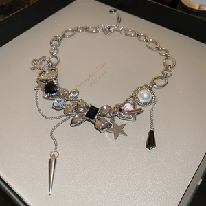 Detail of silver heavy metal punk necklace with butterfly, star and heart charms in a box