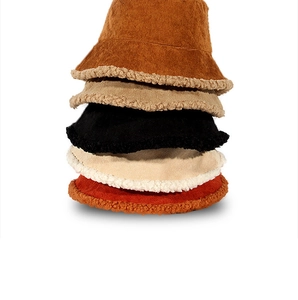 Detailed view of stacked corduroy winter bucket hats with warm faux fur shearling lining