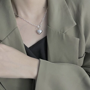 Elegant 925 sterling silver heart necklace with toggle clasp on model wearing blazer